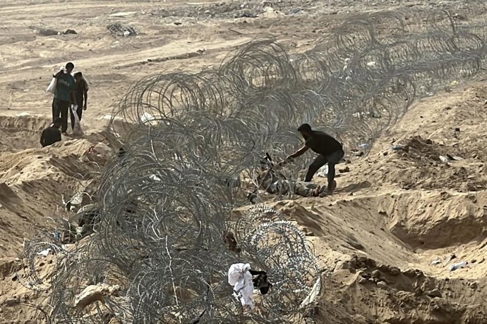 12 de agosto de 2025, Nusairat, Faixa de Gaza, Território Palestino: Palestinos deslocados lutando contra a fome se reúnem em um ponto de distribuição de ajuda montado no Corredor Netzarim na esperança de receber ajuda humanitária limitada em Deir al Bala