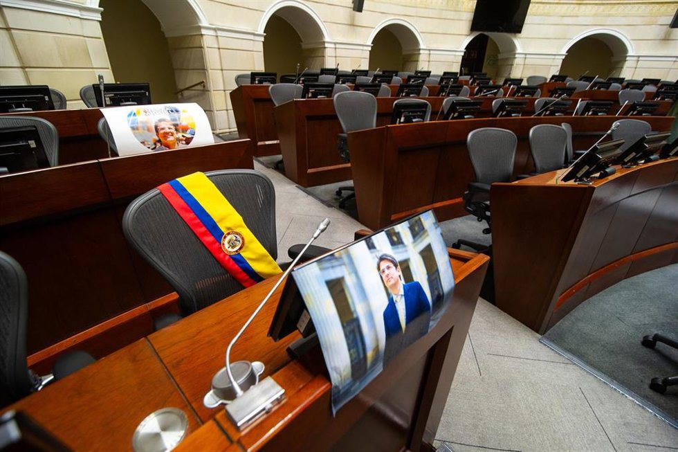 Fotografias y una banda recuerda a Miguel Uribe Turbay en su escaño en el Senado de Colombia.