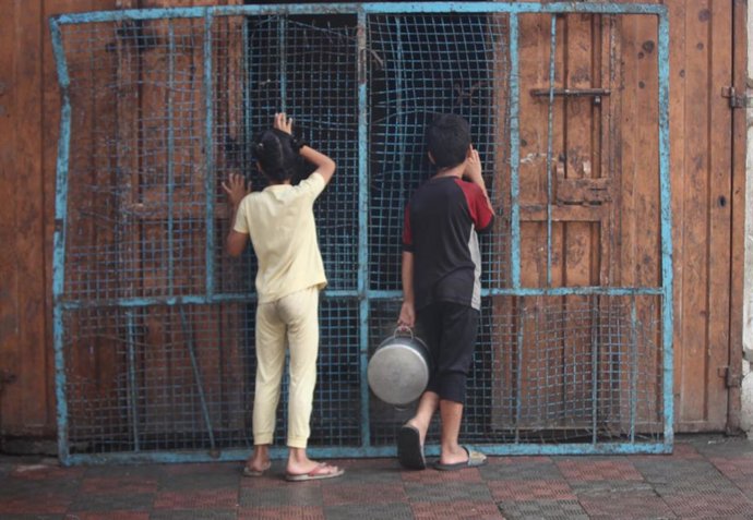 Civiles palestinos esperan para recibir ayuda en Bureij, en la Franja de Gaza