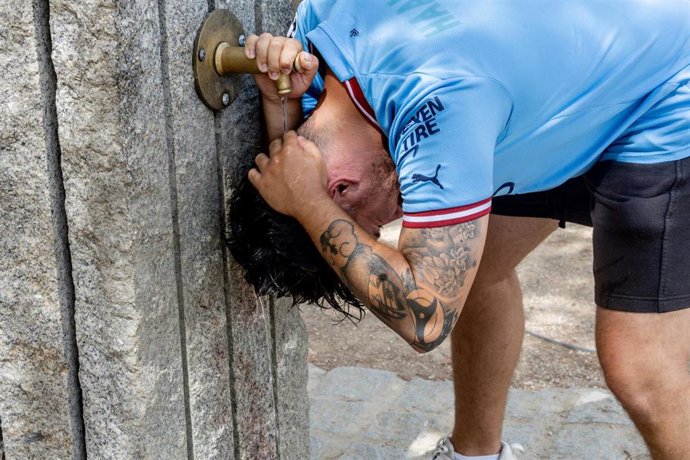 Un chico se moja la cabeza para combatir el calor