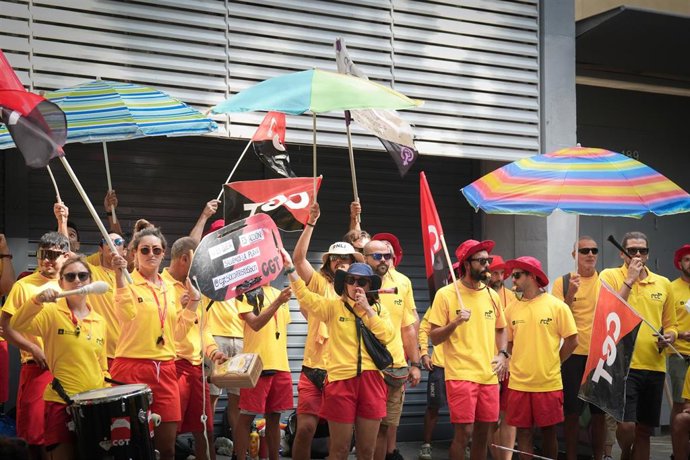 Varias personas protestan durante la huelga indefinida de los socorristas en Barcelona, frente a la sede del PSC, a 4 de agosto de 2025, en Barcelona, Catalunya (España)