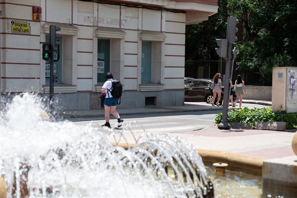 Archivo - Una persona camina junto a una fuente en Badajoz