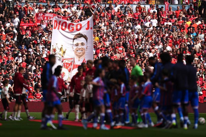 10 August 2025, United Kingdom, Sunderland: Liverpool and Crystal Palace players line up as a banner in memory of Liverpool's Diogo Jota is displayed by fans in the background prior to the start of the English FA Community Shield soccer match between Live