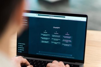 Archivo - Close view of a man with opened AI chat on laptop.