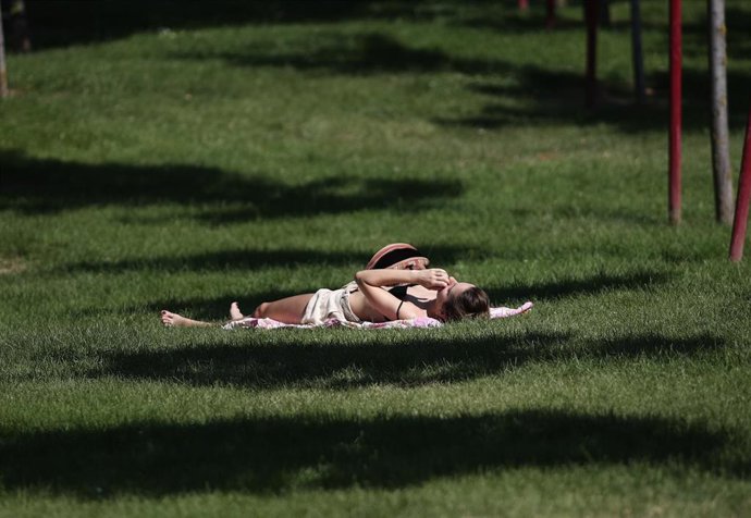 Archivo - Una joven toma el sol en un parque de Madrid, a 23 de junio de 2020.