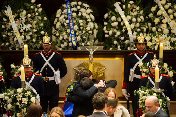 11 de agosto de 2025, Bogotá, Cundinamarca, Colômbia: Um grupo de pessoas se abraça em frente ao caixão enquanto o congresso colombiano realiza uma câmara fúnebre que durará 3 dias. Uribe Turbay, que foi vítima de uma tentativa de assassinato em 7 de junh