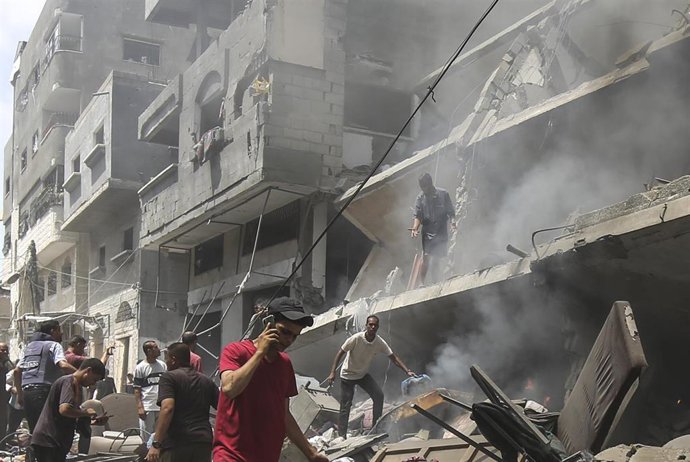 Palestinos comprueban los daños causados por un ataque israelí que ha golpeado el barrio de Al Zeitún, en el sur de la ciudad de Gaza