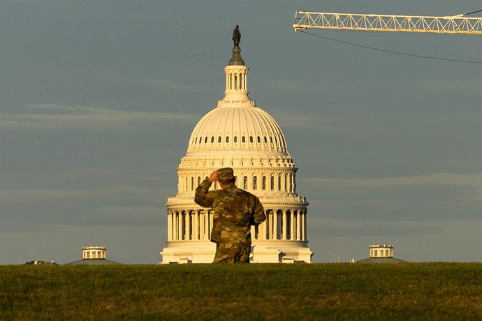12 de agosto de 2025, Washington, Distrito de Columbia, EUA: Um membro da Guarda Nacional ajusta seu boné enquanto olha para o Capitólio dos EUA após sua chegada a Washington. A Guarda Nacional foi ativada na segunda-feira pelo presidente Trump para comba