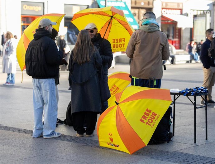 Archivo - Varios guías turísticos por el centro de una ciudad.