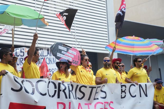 Varias personas protestan durante la huelga indefinida de los socorristas en Barcelona, frente a la sede del PSC, a 4 de agosto de 2025, en Barcelona, Catalunya (España)