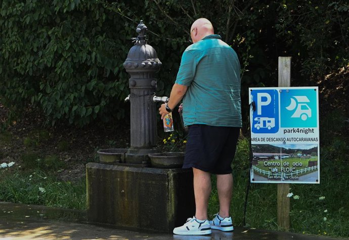 Un hombre bebe agua en una fuente en una jornada de calor de Cantabria. Altas temperaturas