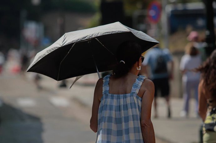 Una mujer se protege del sol con una sombrilla, a 5 de agosto de 2025, en Vigo, Pontevedra, Galicia (España). 