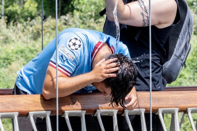 Un chico se moja la cabeza por la ola de calor