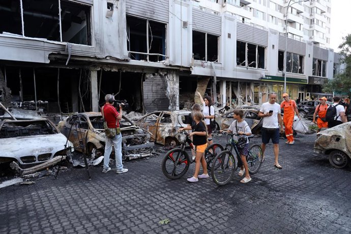 July 22, 2025, Odessa, Ukraine: Children look at the aftermath of a night attack in the Kiev district. As a result of the attack, more than 10 cars were burned down near a residential complex in Kiev district, a grocery store and a sports hall were damage