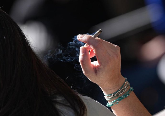 Archivo - Una persona fumando en una terraza.