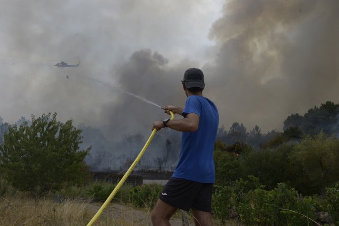 Una persona colabora en la extinción del incendio, a 12 de agosto de 2025, en Seixalbo, Ourense, Galicia (España).