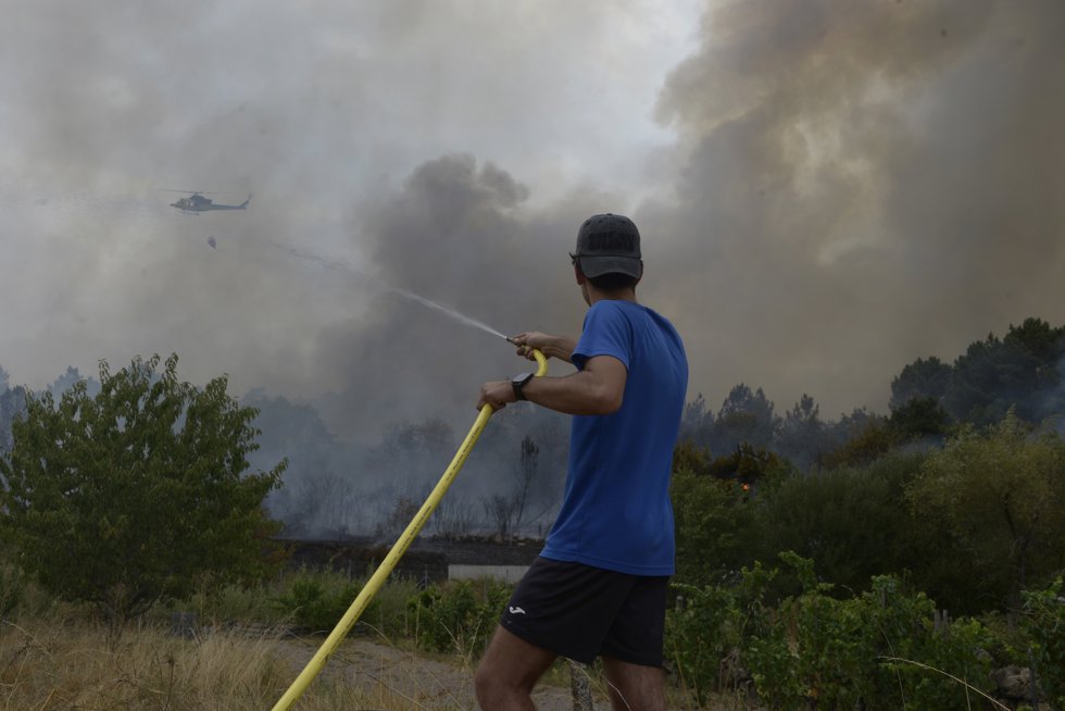 Una persona colabora en la extinción del incendio, a 12 de agosto de 2025, en Seixalbo, Ourense, Galicia (España).