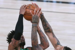 09 August 2020, US, Orlando: Boston Celtics' Marcus Smart (L) and Orlando Magic's Markelle Fultz leap for the ball during the US NBA Basketball match between Orlando Magic and Boston Celtics at the ESPN Wide World of Sports Arena.