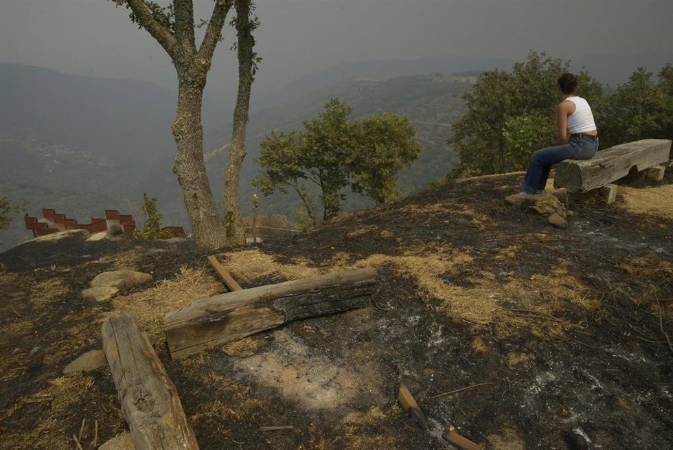 Varios vecinos observan sus fincas tras el paso del fuego, a 13 de agosto de 2025, en Somoza, Pobra de Trives, Ourense, Galicia (España). La jefa de servicio de prevención de incendios forestales en Ourense, Sandra Martínez, ha señalado con preocupación