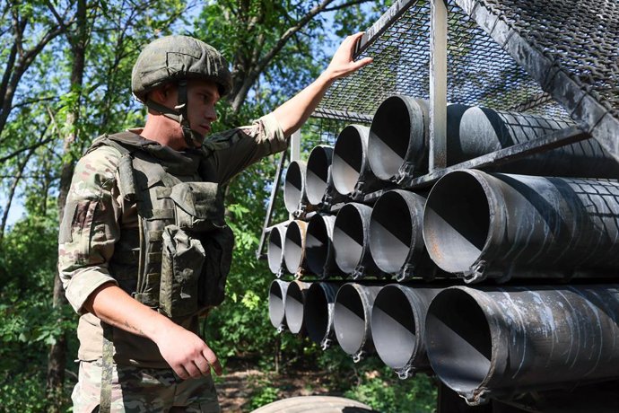 RÚSSIA, REPÚBLICA POPULAR DE DONETSK - 6 DE AGOSTO DE 2025: Um militar da 238ª Brigada de Artilharia do Grupo de Forças Tsentr [Centro] da Rússia é visto por um lançador múltiplo de foguetes BM-27 Uragan na zona da operação militar especial da Rússia