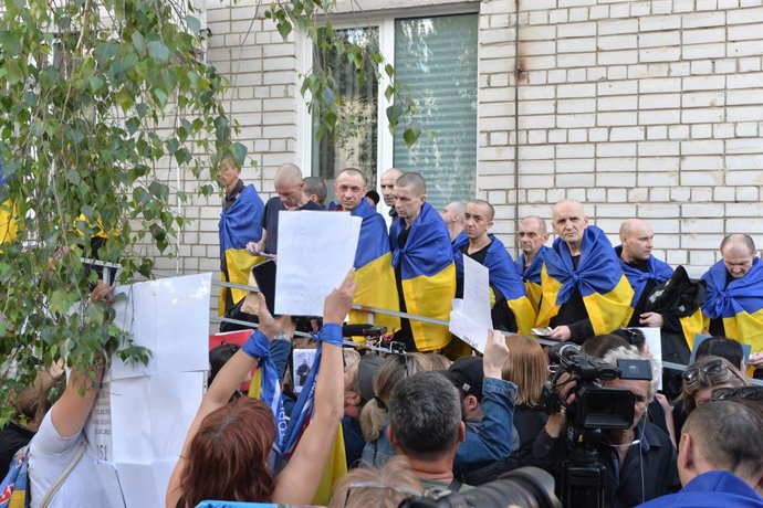 Archivo - 23 May 2025, Ukraine, ---: Ukrainians wear their national flag as they get released as part of the first phase of the 1000 for 1000 prisoner swap between Russia and Ukraine. The first stage of the large-scale prisoner exchange included 390 Ukrai