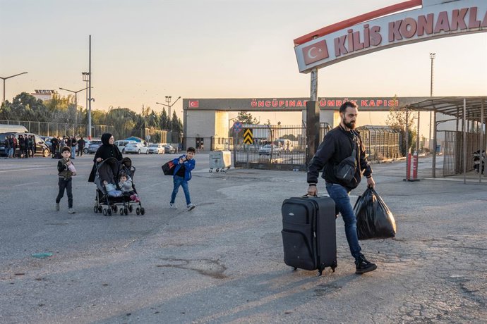 Archivo - 10 December 2024, Turkey, Kilis: Muhammad Dahman, 29, a Syrian migrant, arrive with his family to cross into Syria from Turkey at the Oncupinar border crossing in southern Turkey. Syrian refugees in Turkey started their journey back home followi