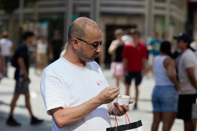 Archivo - Una persona come un helado.