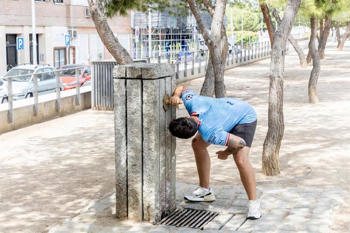 Un chico se moja en una fuente