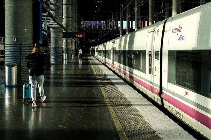 Archivo - (Foto de ARCHIVO) Una mujer camina por el andén junto a un tren de AVE de Renfe estacionado en las vías de la Estación de Atocha