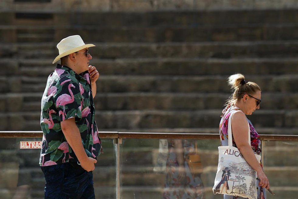 Personas con ropa veraniega y sombreros.