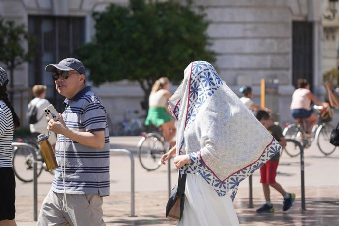 Archivo - Dos personas caminan por la calle durante la cuarta ola de calor del verano, a 22 de agosto de 2023, en Valencia