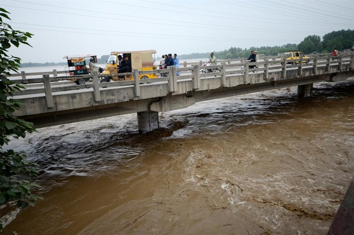 August 15, 2025, Peshawar, Peshawar, Pakistan: More than 160 people killed in Pakistan in heavy rains, flash floodsPESHAWAR, PAKISTAN, AUGUST 15: Local residents gather to watch the swallen Charsadda river flow under a bridge following heavy monsoon rainf