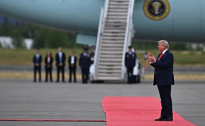 HANDOUT - 15 de agosto de 2025, EUA, Alasca: O presidente dos EUA, Donald Trump, aplaude em um tapete vermelho enquanto aguarda o presidente da Rússia, Vladimir Putin (não retratado), antes de seu encontro no Alasca. Foto: Sergey Bobylev/Kremlin/dpa - ATE