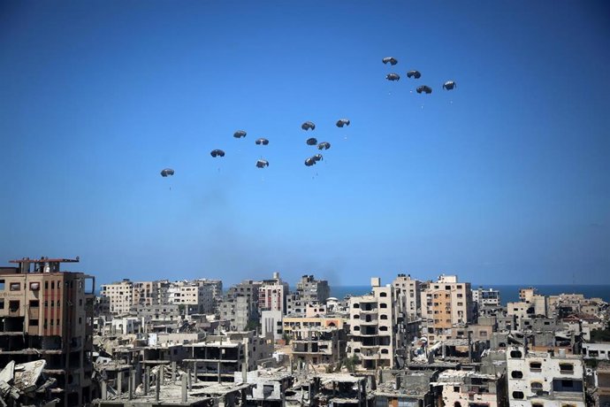 06 August 2025, Palestinian Territories, Gaza: A German military aircraft loaded with humanitarian aid drops supplies over Gaza, as seen from the northern Gaza Strip. Photo: Omar Ashtawy/APA Images via ZUMA Press Wire/dpa