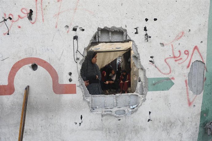 Civiles palestinos examinan los daños de un ataque en la ciudad de Gaza