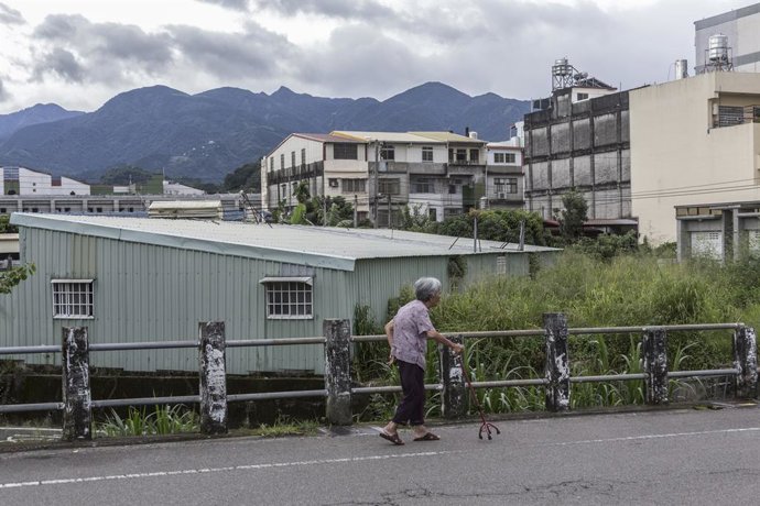 August 13, 2025, Taichung, Taiwan: An elderly woman walks with a quadruped cane along a street in Taichung, Taiwan.