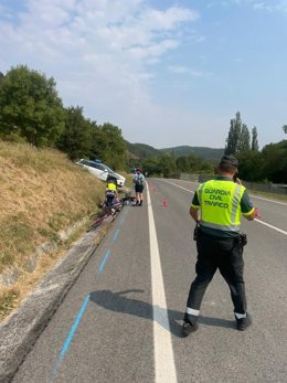 Agentes de la Guardia Civil y otros ciclistas atienden al herido.