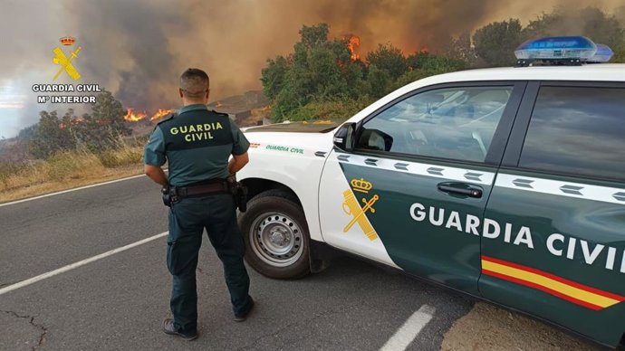 Un coche de la Guardia Civil frente a un incendio.