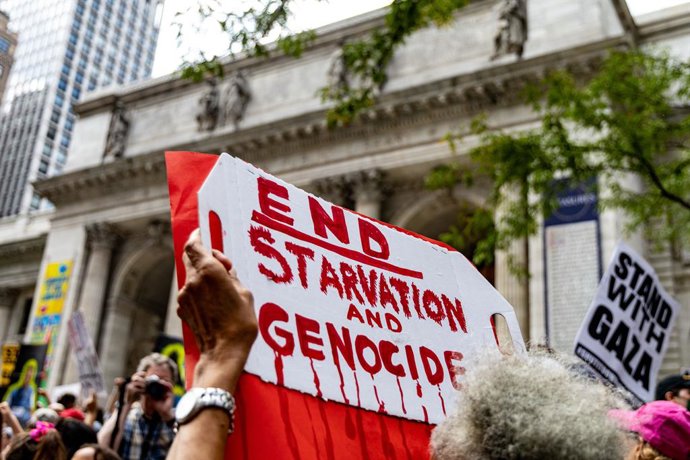 16 de agosto de 2025, Nova York, Nova York, EUA: Um manifestante segura um cartaz com os dizeres "END STARVATION AND GENOCIDE" (Acabe com a fome e o genocídio) em um protesto do lado de fora da Biblioteca Pública de Nova York, em Manhattan.