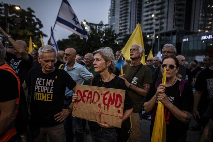 12 de agosto de 2025, Tel Aviv, Israel: Um homem israelense olha para um cartaz segurado por um manifestante durante uma manifestação contra a guerra organizada por pilotos aposentados da Força Aérea Israelense. Os manifestantes pediram ao governo israele