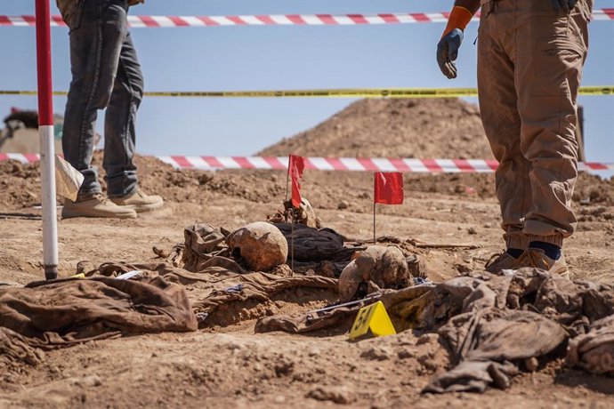 Archivo - 13 June 2021, Iraq, Al-Humaydat: Human remains lie on the ground after being exhumed by members of expert teams during the opening of a mass grave of victims who were killed and buried by the so-called Islamic State (IS) terror group back in 201
