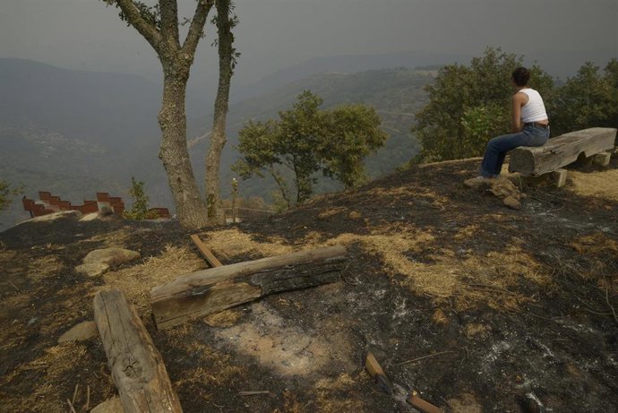Varios veciños observan as súas leiras após o paso do lume, a 13 de agosto de 2025, en Somoza, Pobra de Trives, Ourense, Galicia (España). 