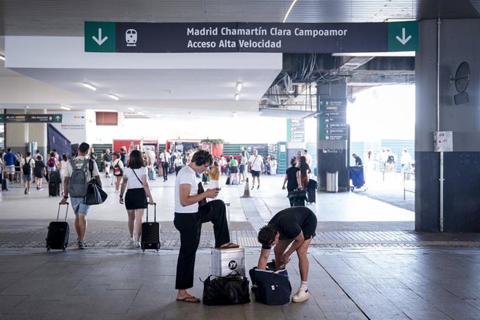 Varias personas esperan con maletas en la estación de Chamartín Clara Campoamor, a 14 de agosto de 2025, en Madrid (España). Renfe mantiene interrumpida la circulación de trenes entre Galicia y Madrid por los incendios en Ourense y continúa revisando la i