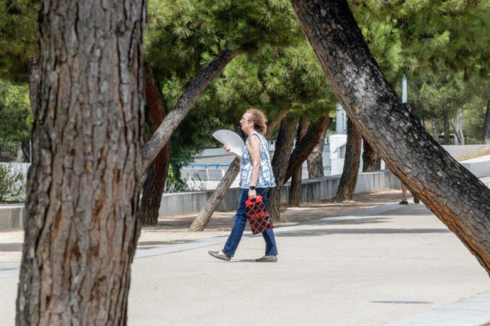 Una mujer se abanica, a 12 de agosto en Madrid (España). La Agencia Estatal de Meteorología (AEMET) ha extendido el aviso por ola de calor "probablemente hasta el lunes 18 de agosto". Dado que comenzó el pasado día 3, esto supondría que la ola de calor se