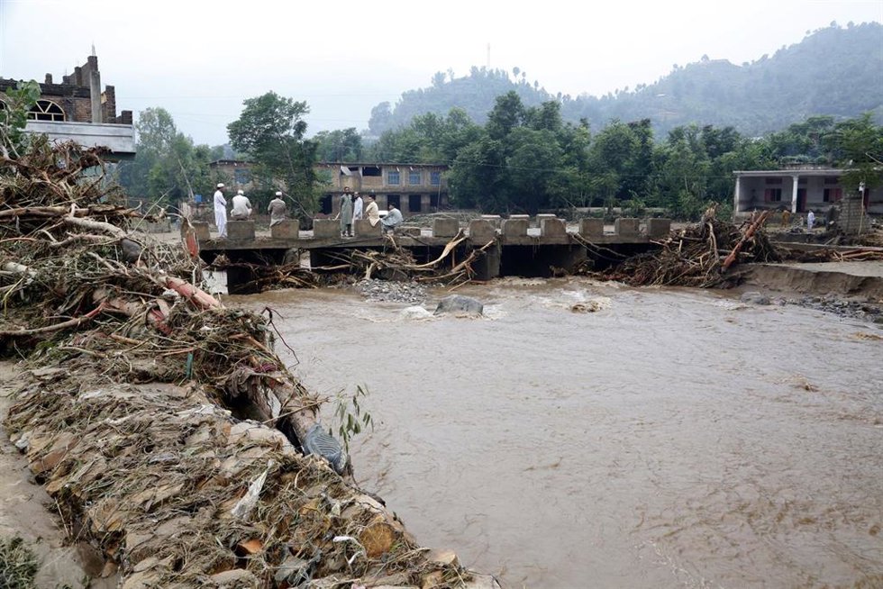 Residentes tratan de limpiar sus locales tras las inundaciones  en el distrito de Buner, en el norte de Pakistán