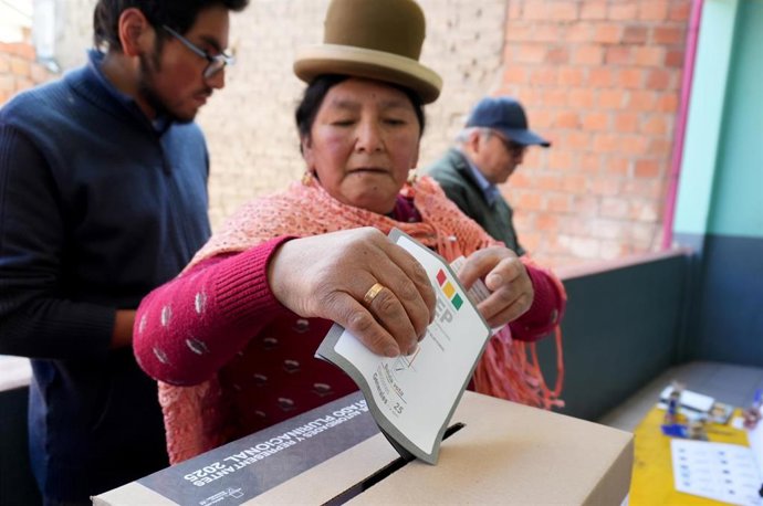 Una mujer indígena inserta su papeleta en la urna para elegir presidente en Bolivia