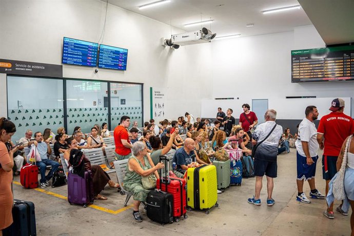 Varias personas esperando, en la Estación de Chamartín Clara Campoamor.