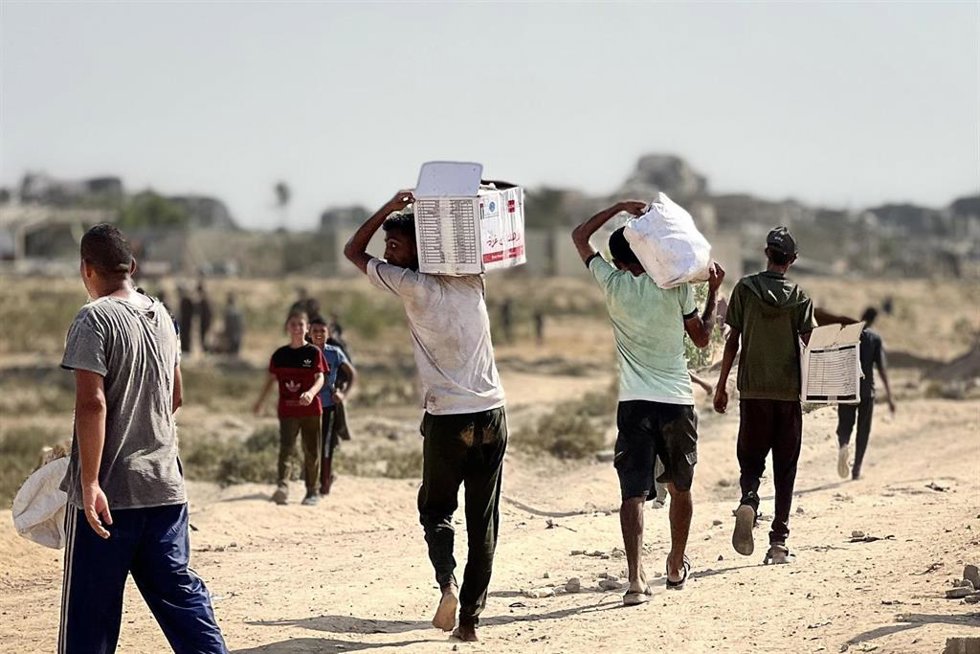 14 August 2025, Palestinian Territories, Nuseirat: Palestinians retrieve aid packages parachuted during an airdrop over Nuseirat in the central Gaza Strip. Photo: Belal Abu Amer/APA Images via ZUMA Press Wire/dpa