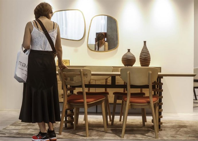 Archivo - Una mujer observa una mesa durante la inauguración de la edición 2022 de los certámenes Hábitat Valencia, Home Textiles Premium y Espacio Cocina Sici, a 20 de septiembre de 2022, en Valencia, Comunidad Valenciana (España). Feria Valencia celebra