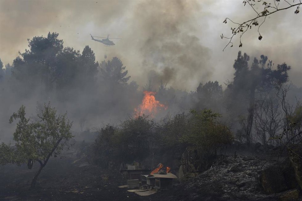 Un helicóptero trata de extinguir un incendio en Galicia. 